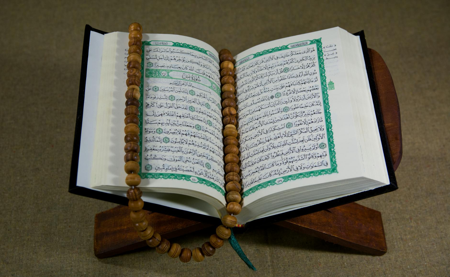 close up shot of a book beside prayer beads