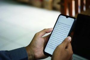 man hands holding smartphone digital quran