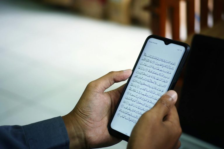 man hands holding smartphone digital quran