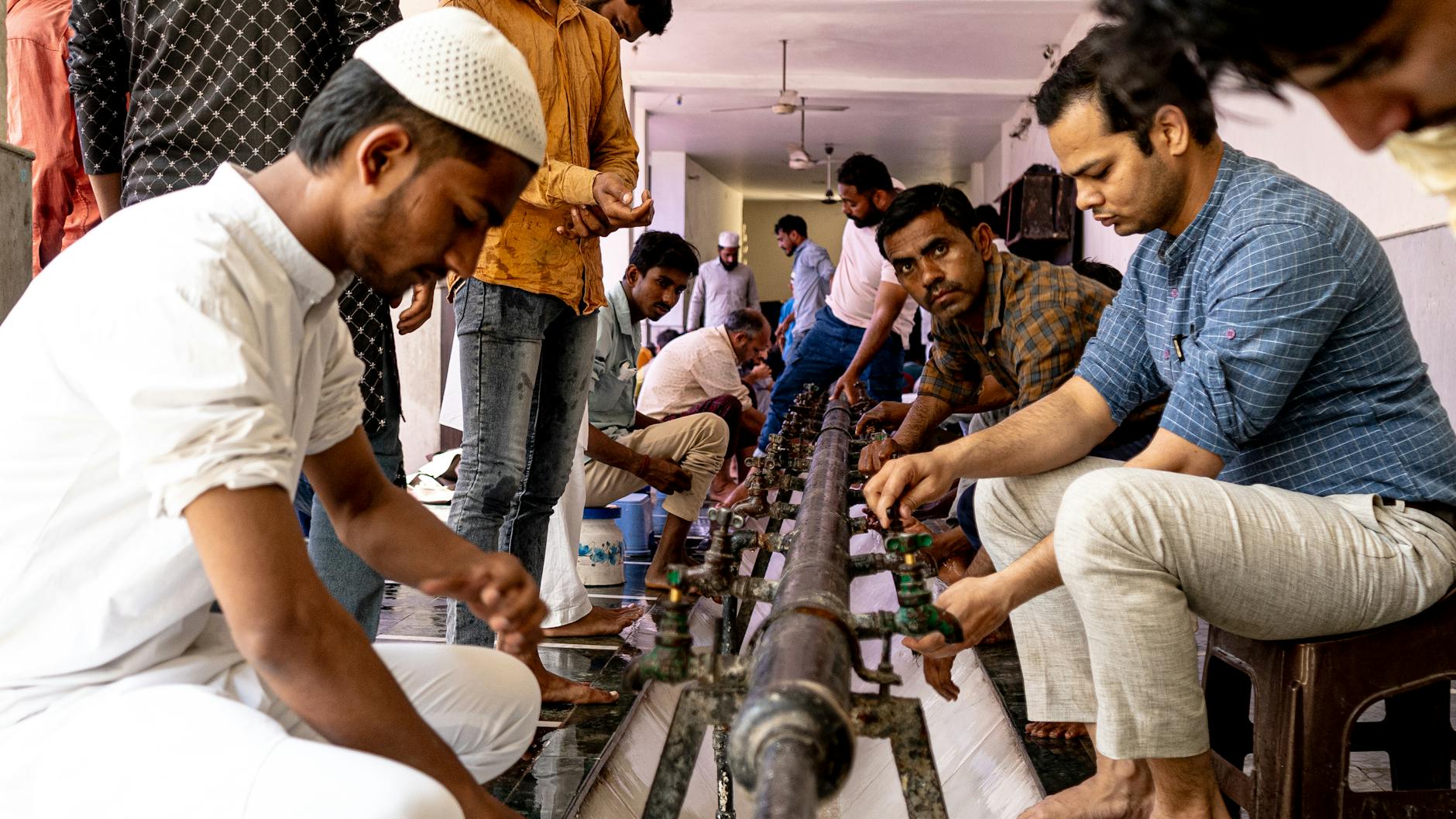 men performing ritual ablution in mosque