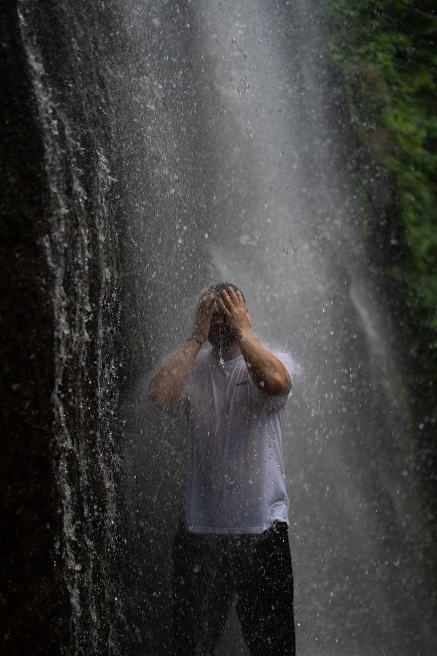 man enjoying refreshing waterfall shower