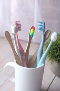 close up photo of toothbrushes on a ceramic cup