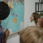 teacher teaching students about geography using a map